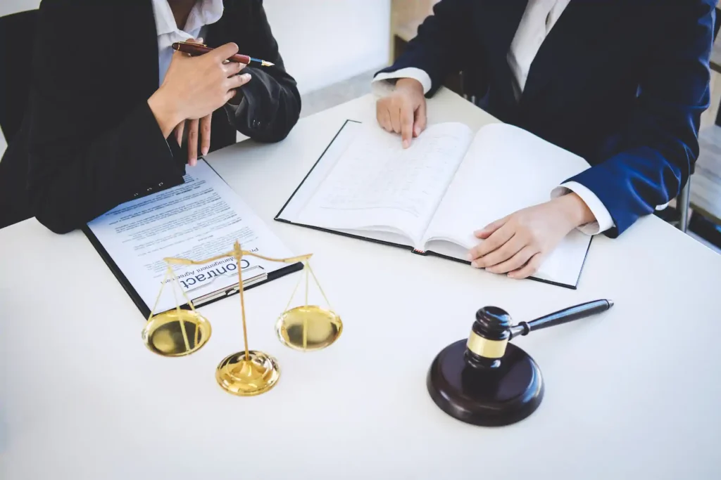Abogados revisando contrato con balanza y mazo