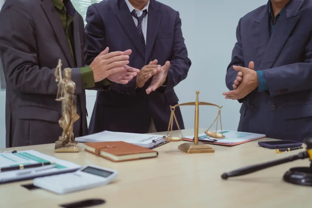 Abogados aplaudiendo junto a balanza de justicia