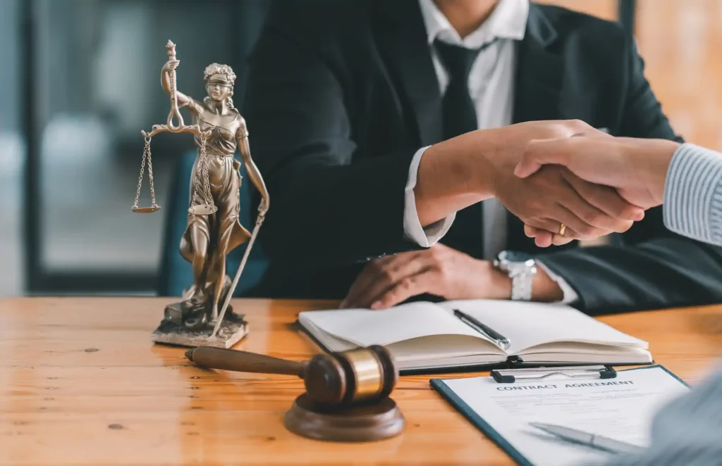 Apretón de manos frente a estatua de justicia