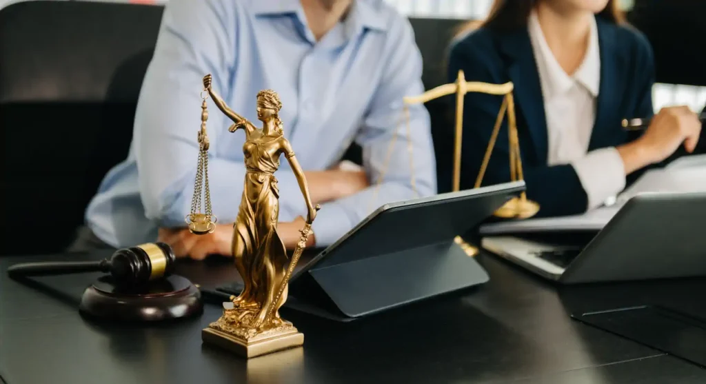 Estatua de la Justicia y abogados trabajando