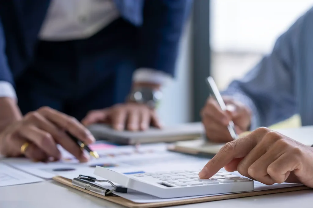 Personas calculando finanzas en escritorio de oficina