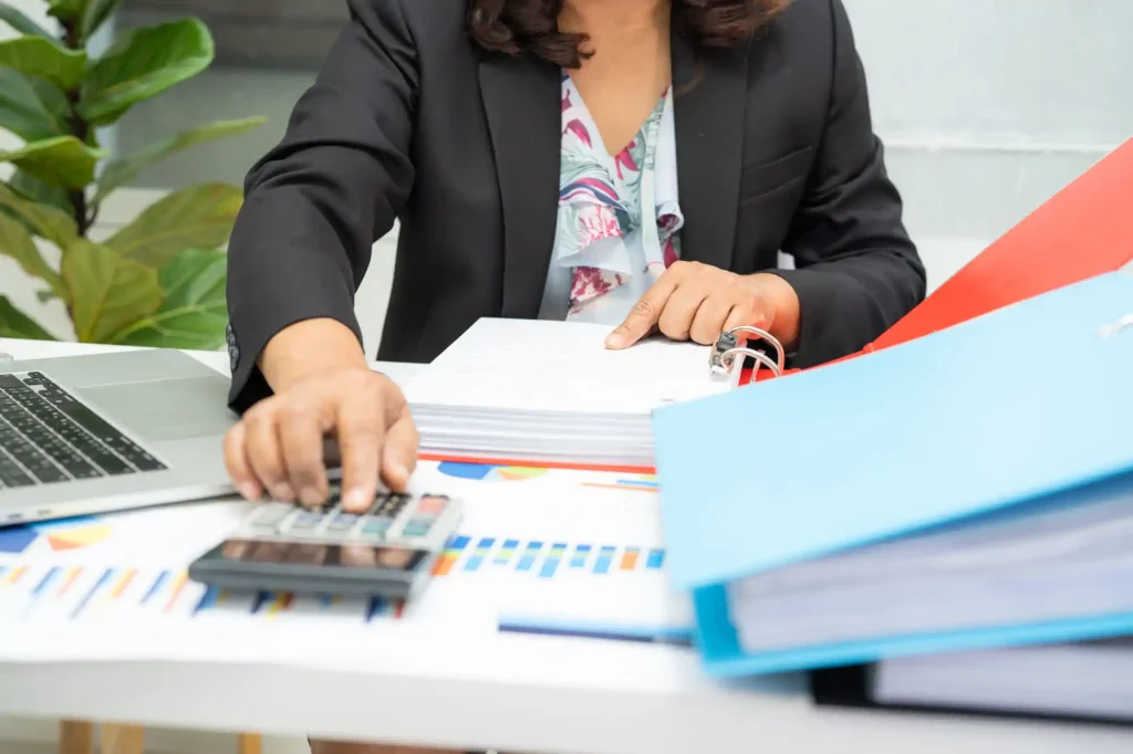 Mujer calculando finanzas en escritorio de oficina