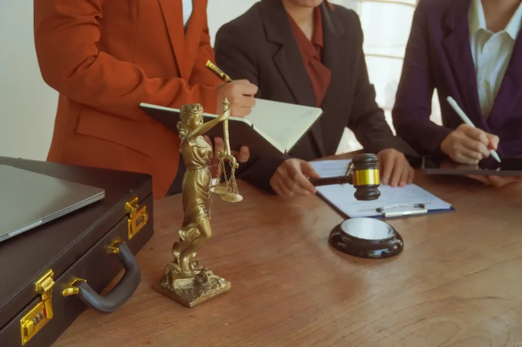 Abogados revisando documentos con estatua de la justicia