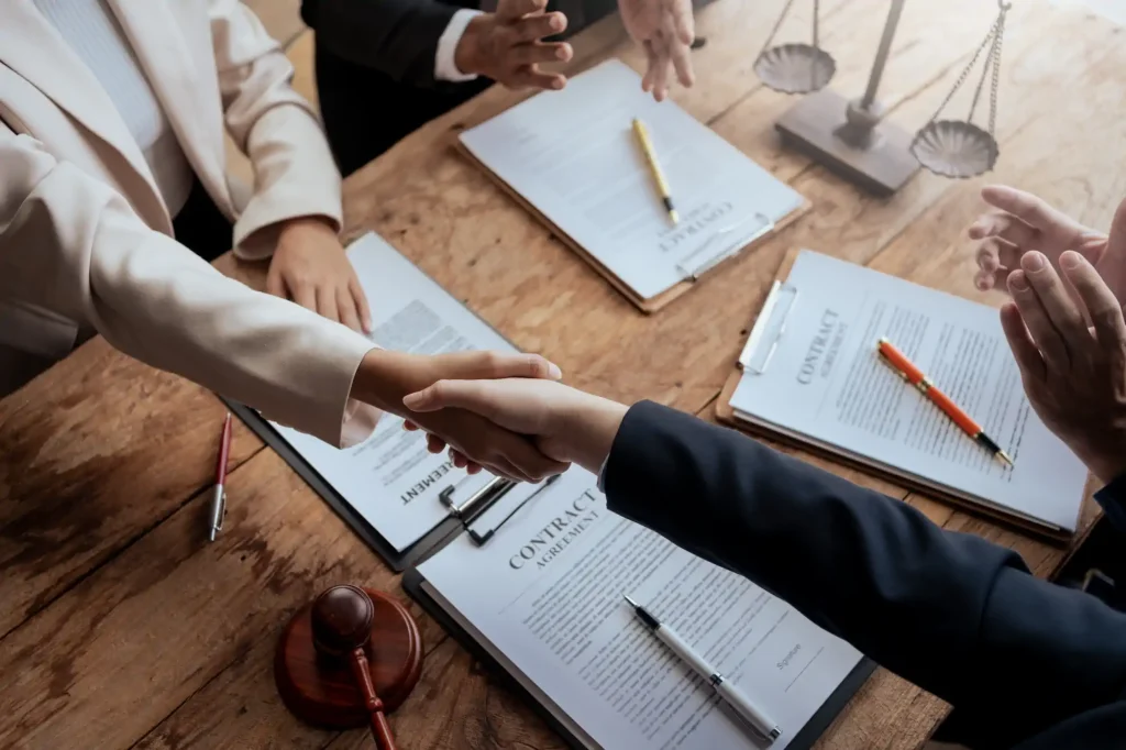 Apretón de manos sobre contrato legal firmado