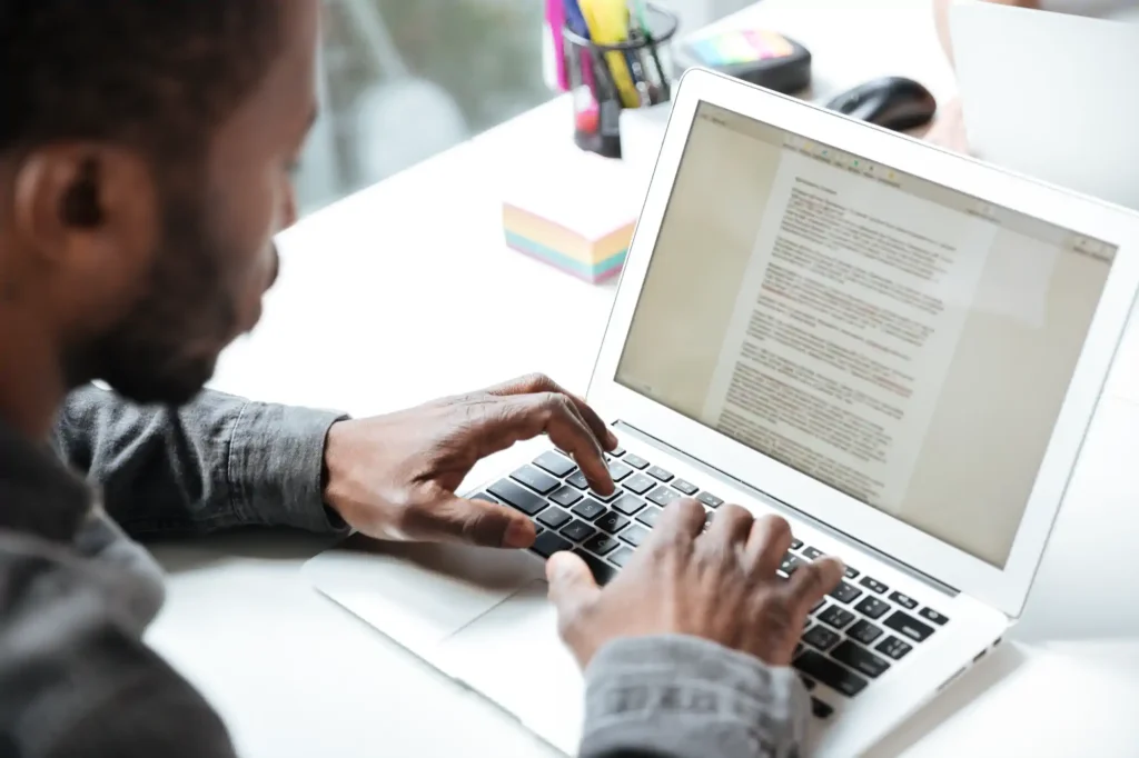 Hombre redactando un documento en una laptop