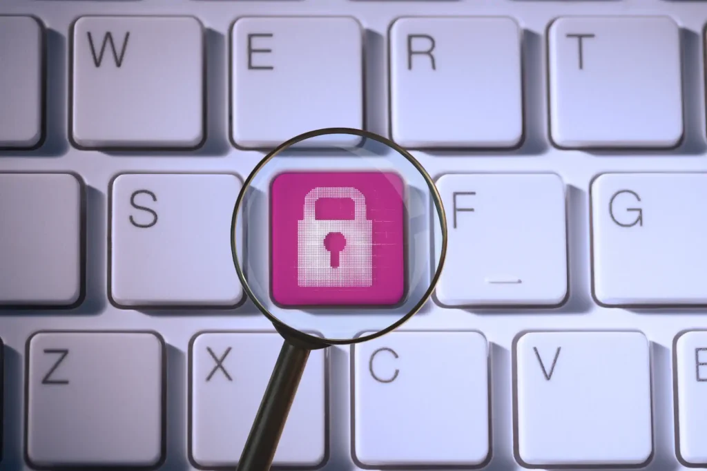 Lupa enfocando tecla rosa con candado en teclado