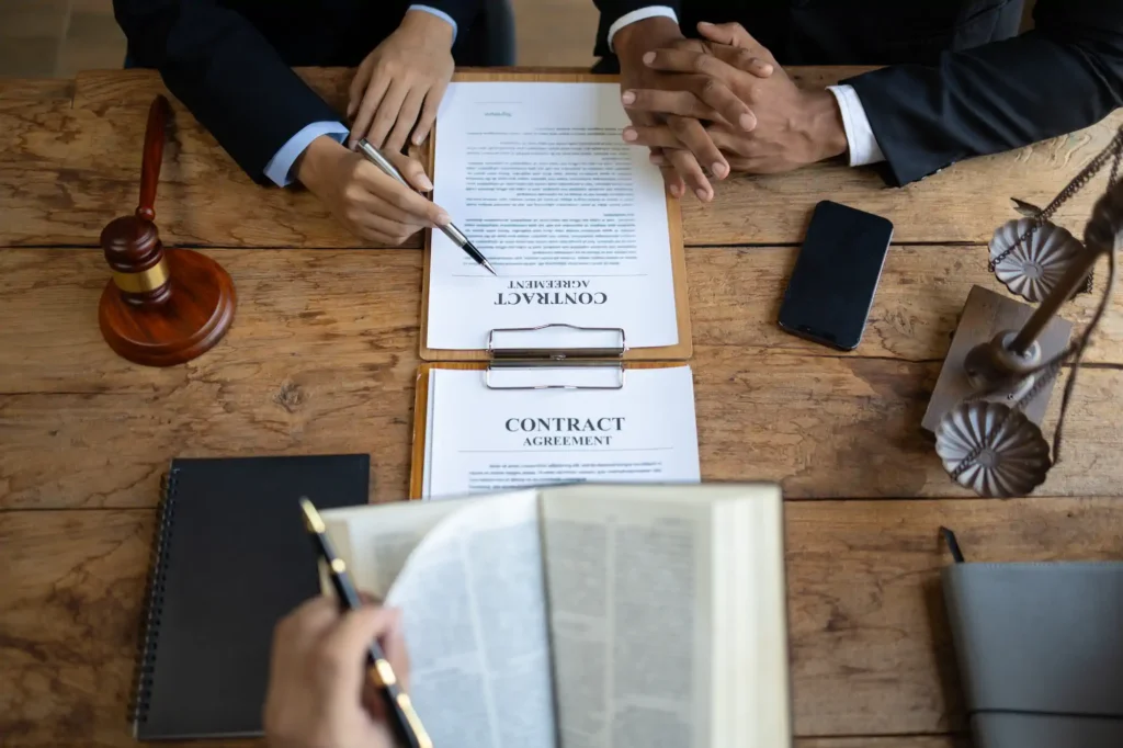 Abogados revisan contrato junto a mazo y balanza