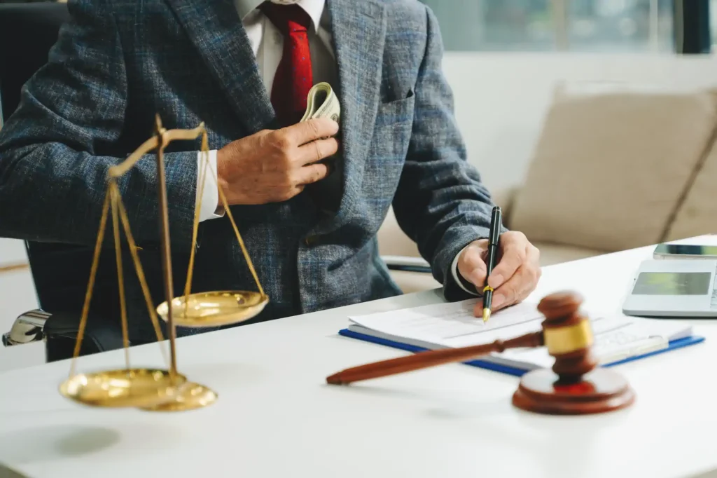 Abogado firma documentos con balanza y mazo judicial
