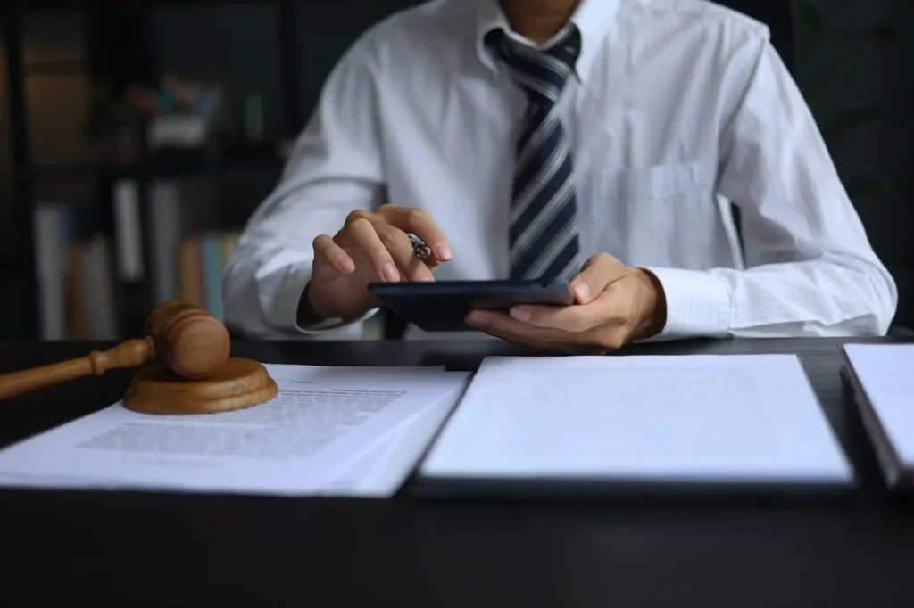Abogado revisa documentos legales en tableta junto a mazo