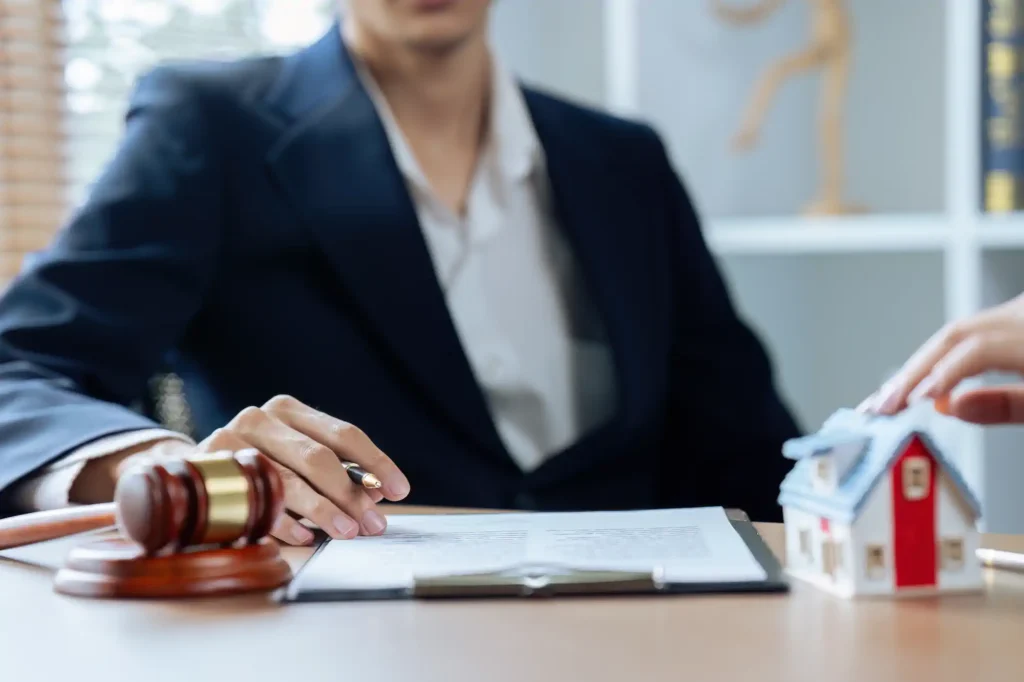 Abogada revisa contrato inmobiliario junto a maqueta de casa